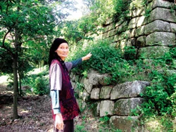 Cụ Phạm Thị Tẹo bên chân cột đá Lãm Sơn Tự.